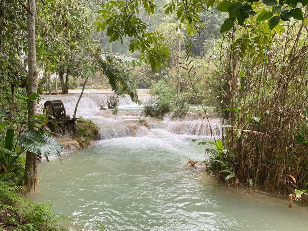 A series of small waterfalls with blue-green water.