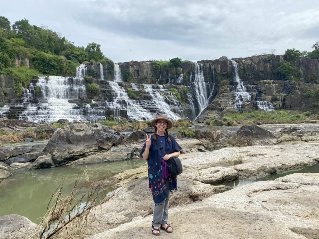 Woman posing in front of waterfalls in Dalat, Vietnam.