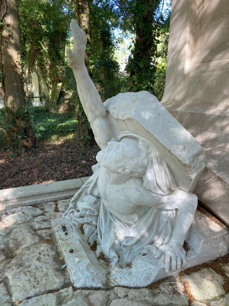 The grave of Jules Verne at La Madeleine Cemetery, featuring a sculpture of Verne lifting his own tombstone.