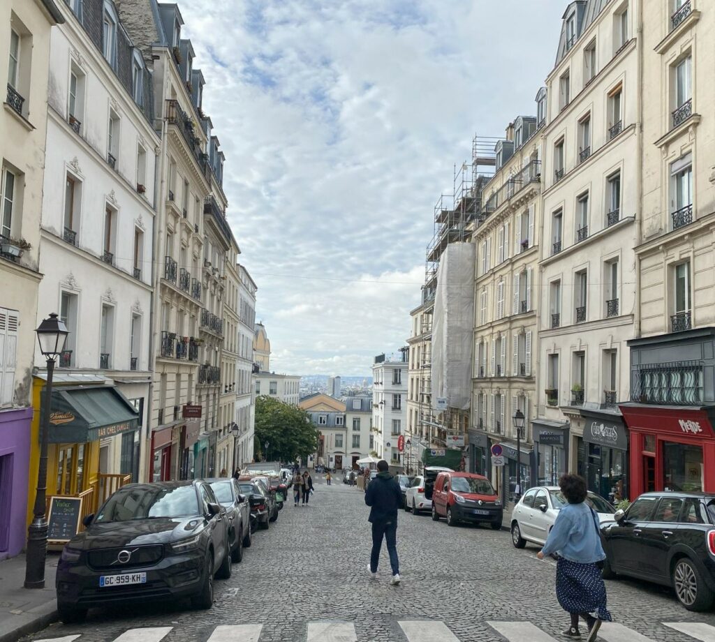 A picturesque street in Montmartre, lined with old buildings and cobblestone paths.