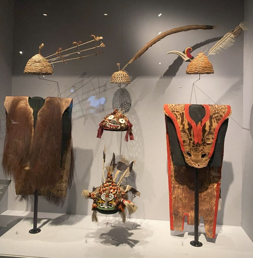 Two traditional Bornean tribal outfits, with four coordinating hats.