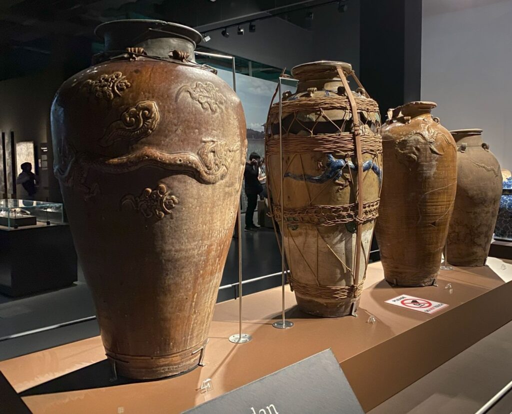 Four enormous jugs with designs carved on them.