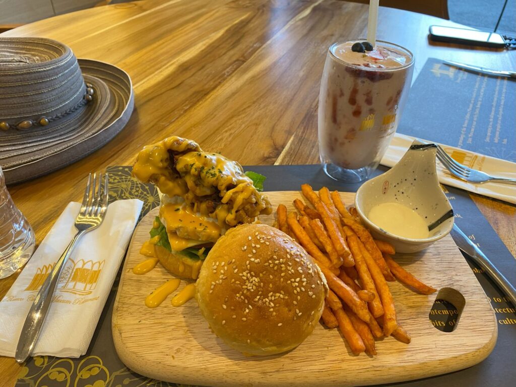 A plate of food: crab burger, sweet potato fries and a dipping sauce.