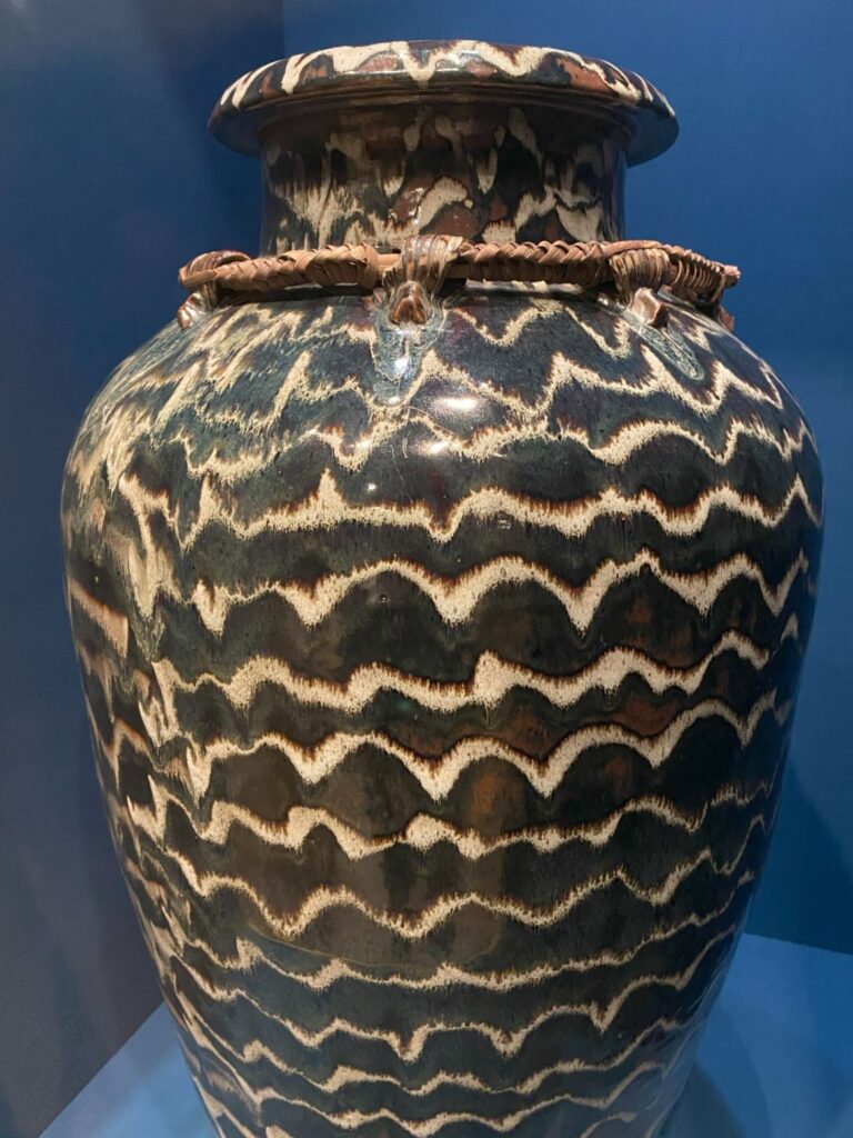 A large pot with a wavy pattern in dark brown and light tan colors.