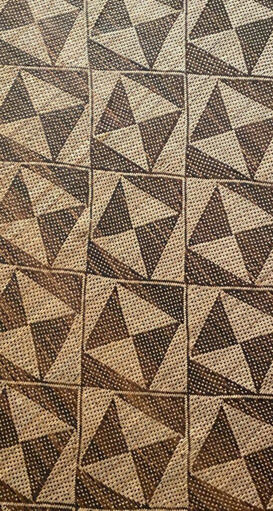 Close-up of a woven pattern made of triangles in dark brown and tan colors.