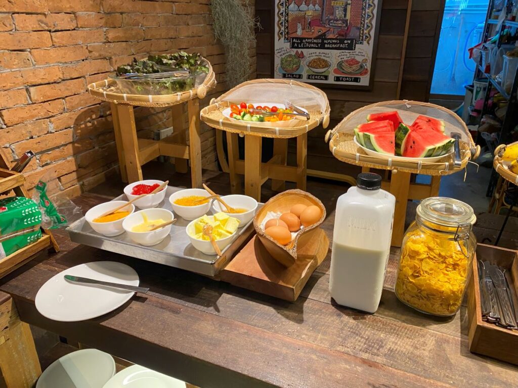 A self-serve breakfast buffet with various hot and cold options for hostel guests.