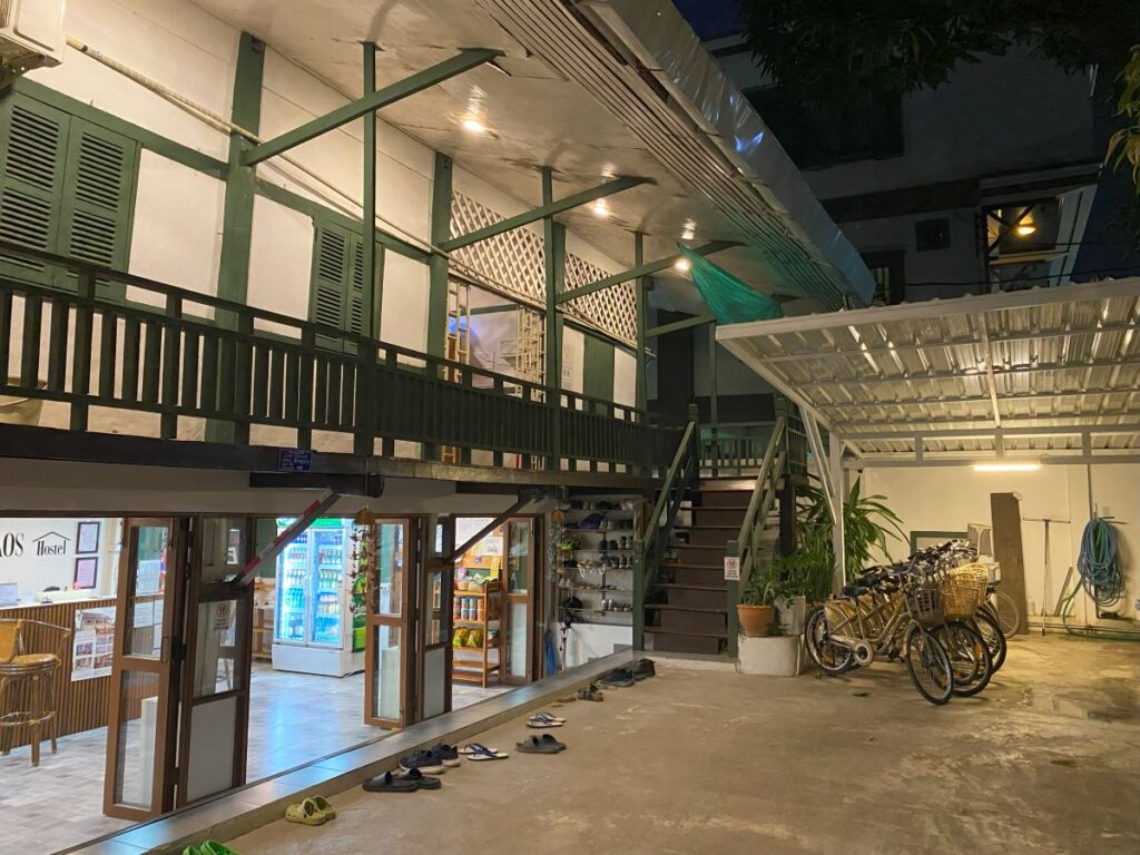 The front entrance of the hostel with a reception desk and outdoor seating area.